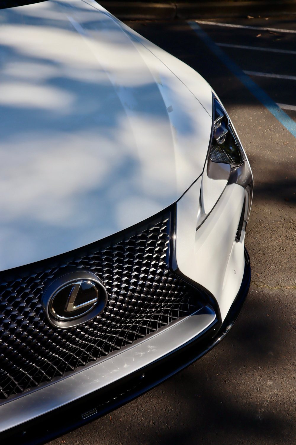 Gloss reflections on the hood and grille of a white Lexus LC in Rancho Cordova