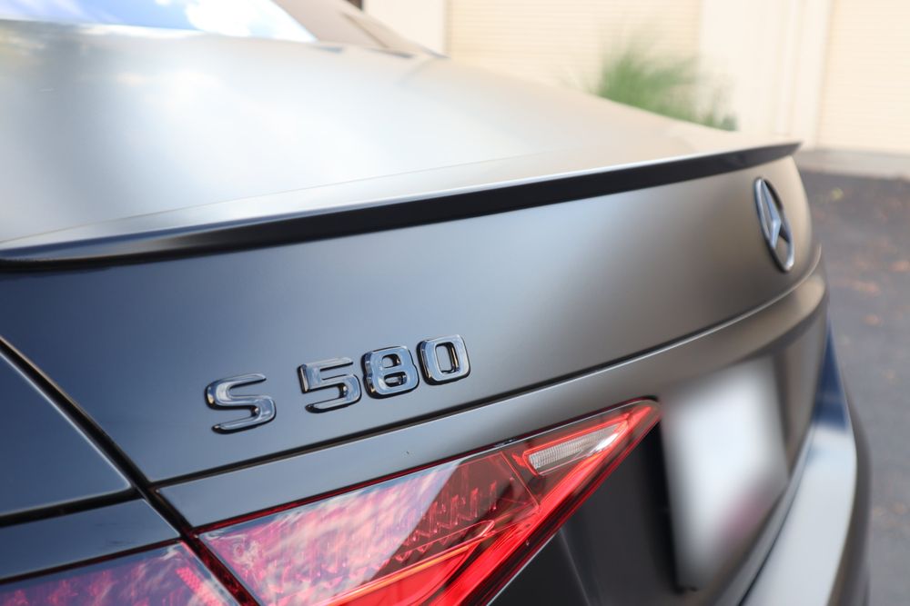 Blacked-out S580 badge on the trunk of a Mercedes-Benz S580 with a satin black wrap and full chrome delete by Drift Wraps