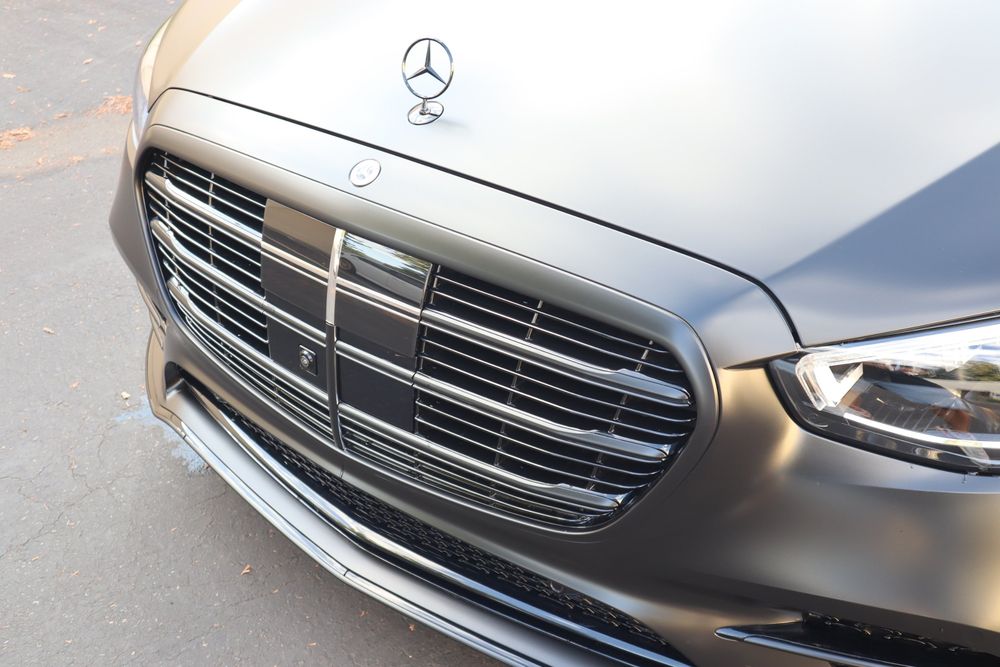 Grille and hood emblem on a Mercedes-Benz S580 with a satin black wrap and full chrome delete by Drift Wraps