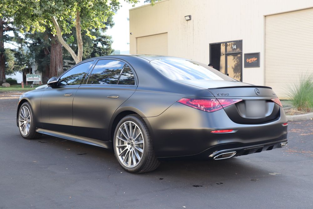 Rear three-quarter view of a Mercedes-Benz S580 with a satin black wrap and full chrome delete by Drift Wraps