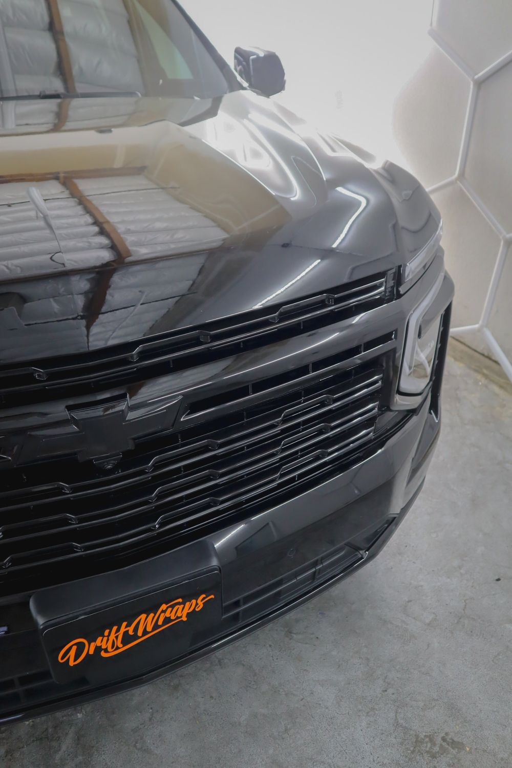 Blacked-out grille and bowtie on a Chevrolet Tahoe High Country with gloss black chrome delete by Drift Wraps