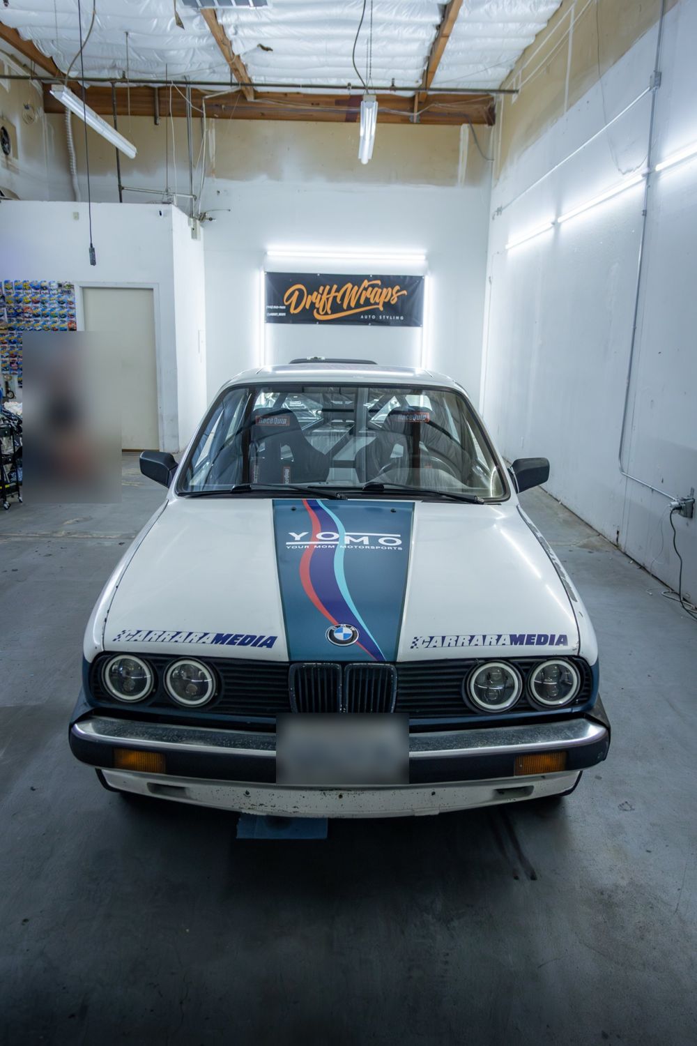 Front of a 1985 BMW 325e with a custom rally livery for Your Mom Motorsports by Drift Wraps