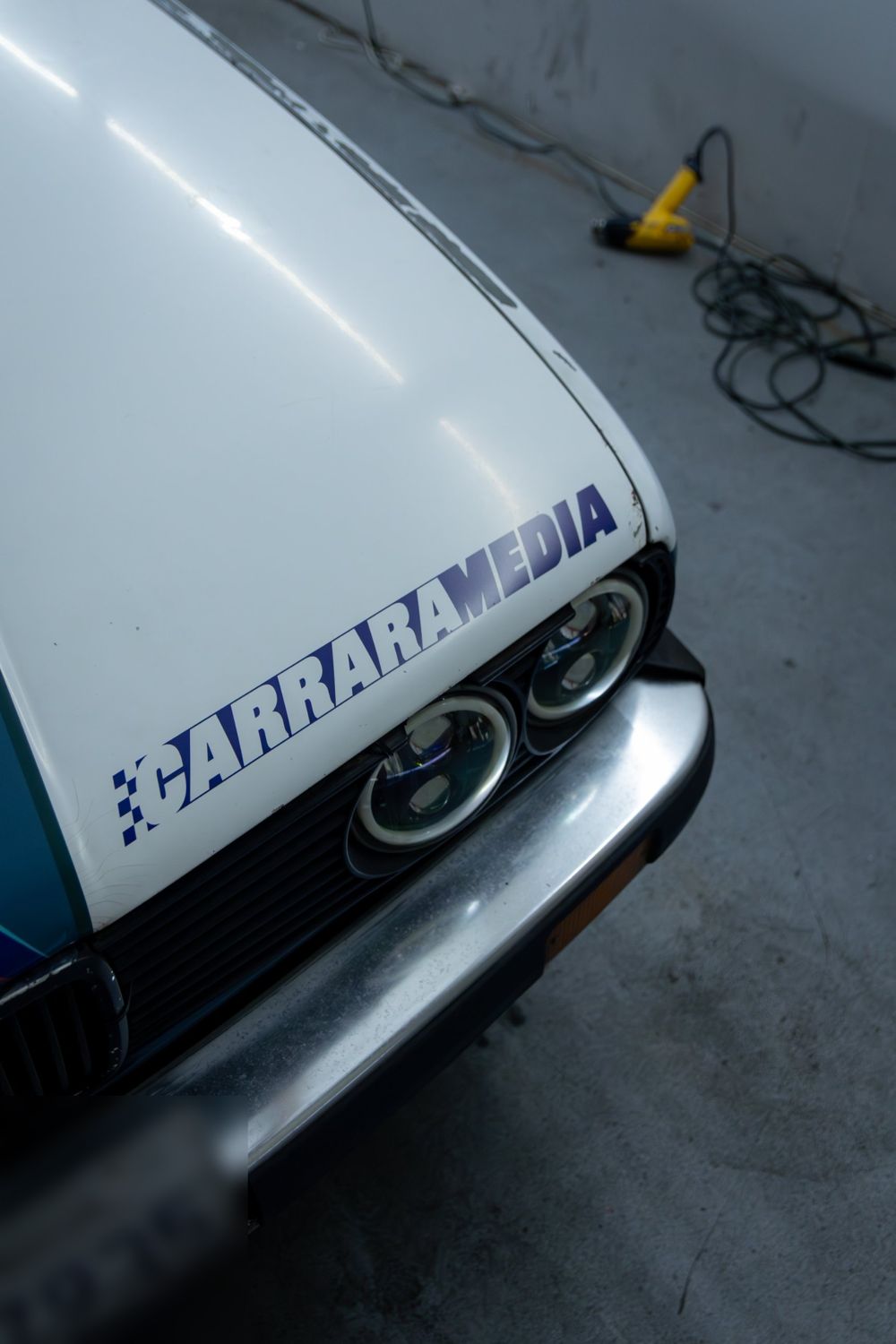 Hood sponsor graphic on a 1985 BMW 325e with a custom rally livery for Your Mom Motorsports by Drift Wraps