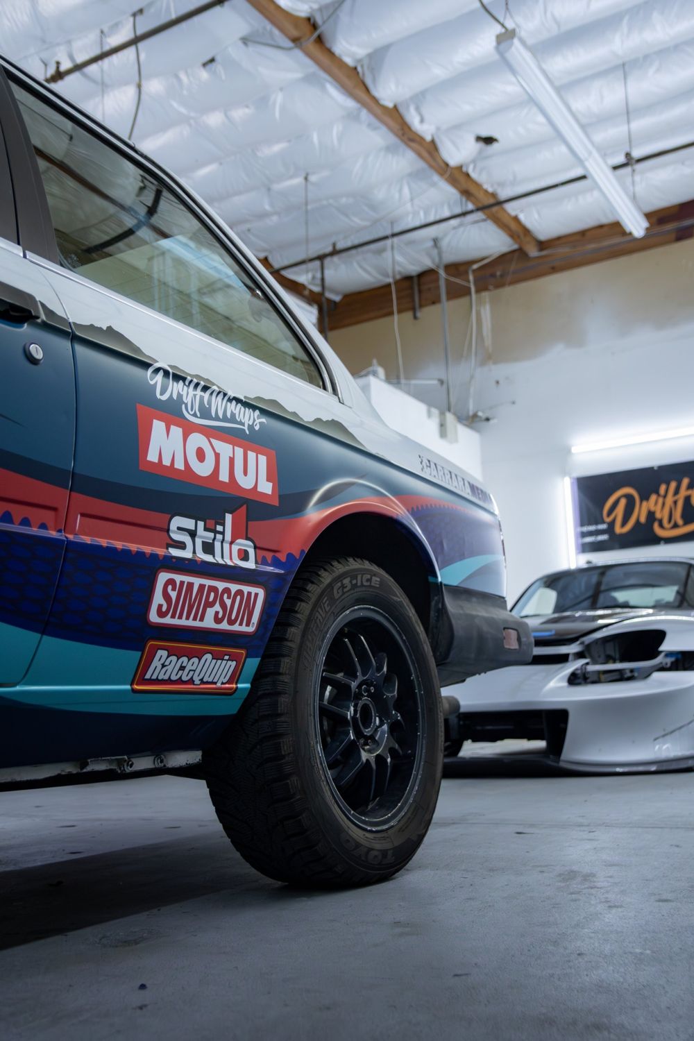 Rear quarter livery on a 1985 BMW 325e with a custom rally livery for Your Mom Motorsports by Drift Wraps