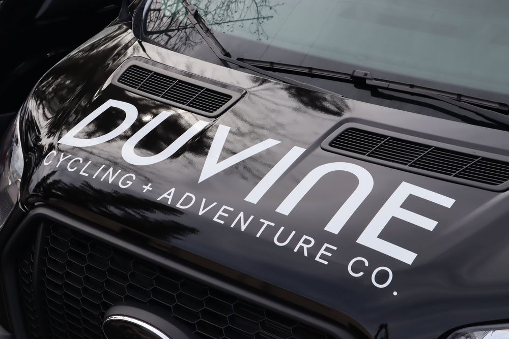 Hood logo on a DuVine Cycling + Adventure Co. Ford Transit van with a full wrap and custom decal text by Drift Wraps in Rancho Cordova