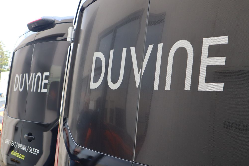 Rear door window graphics on two DuVine Cycling + Adventure Co. Ford Transit vans with a full wrap and custom decal text by Drift Wraps in Rancho Cordova