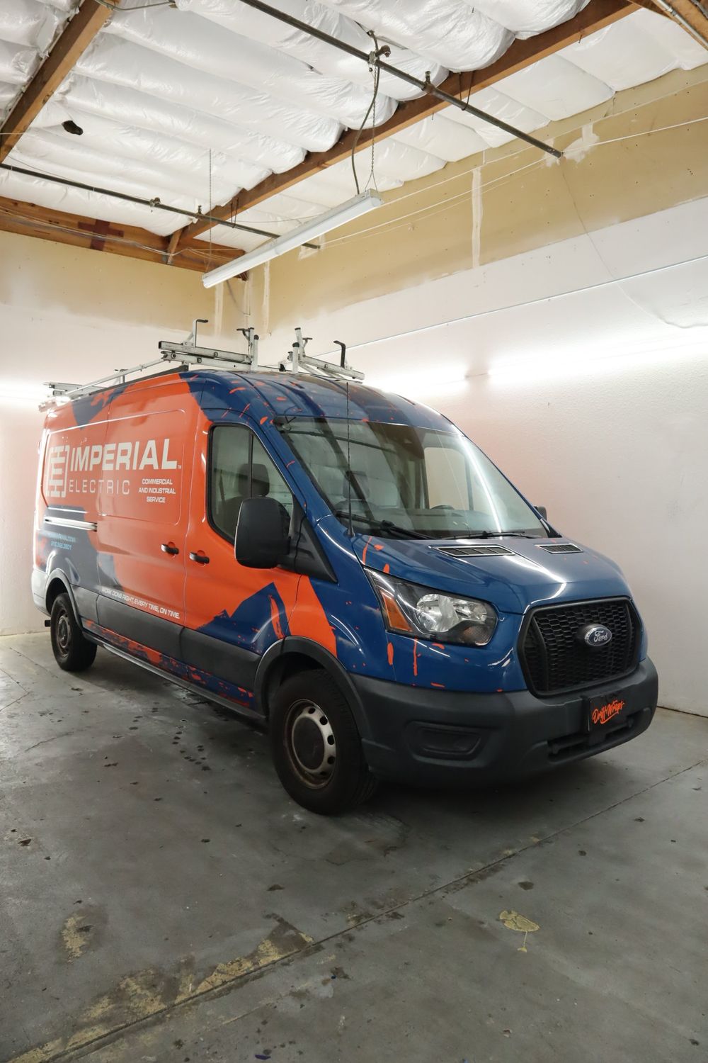 Front three-quarter view of an Imperial Electric Ford Transit van with a full custom design wrap by Drift Wraps in Rancho Cordova
