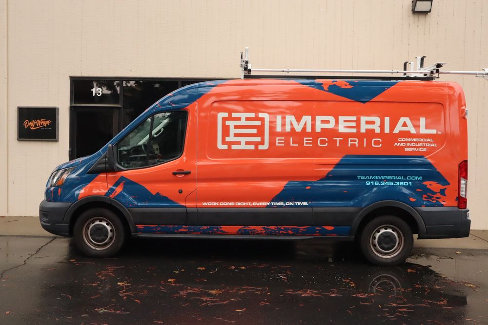 Side profile of an Imperial Electric Ford Transit van with a full custom design wrap by Drift Wraps in Rancho Cordova outside the Drift Wraps shop