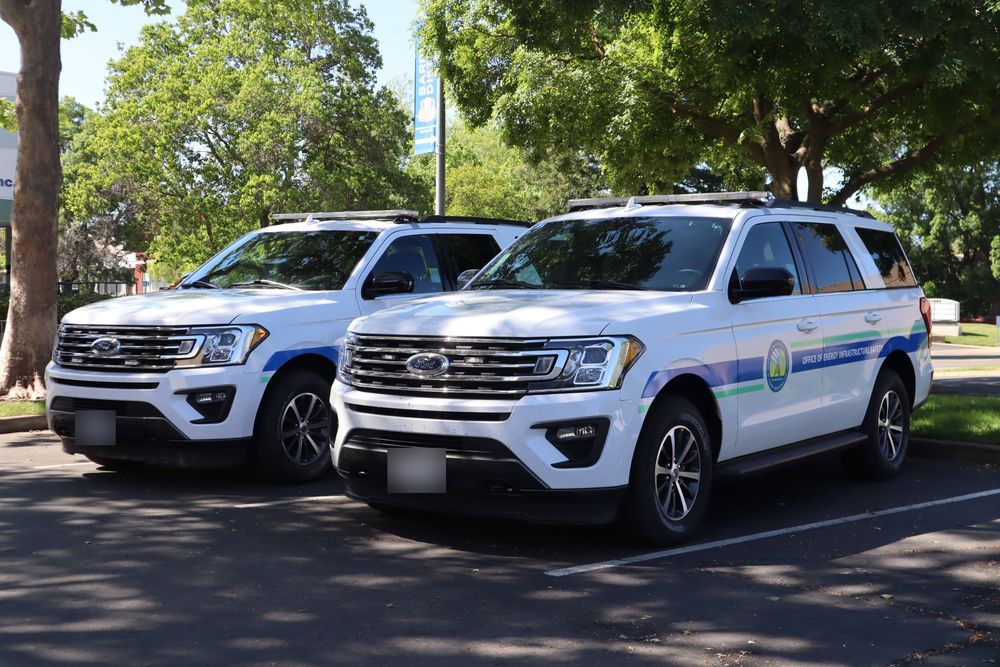 Front three-quarter view of two California state agency Ford Expeditions with custom decals by Drift Wraps in Rancho Cordova