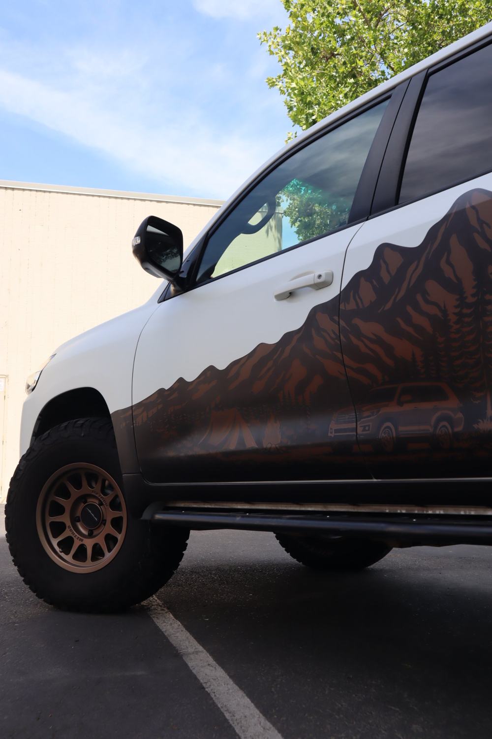 Low angle of the front door and mountain graphic on a 2016 Toyota Land Cruiser with full-body matte PPF over custom graphics by Drift Wraps in Rancho Cordova