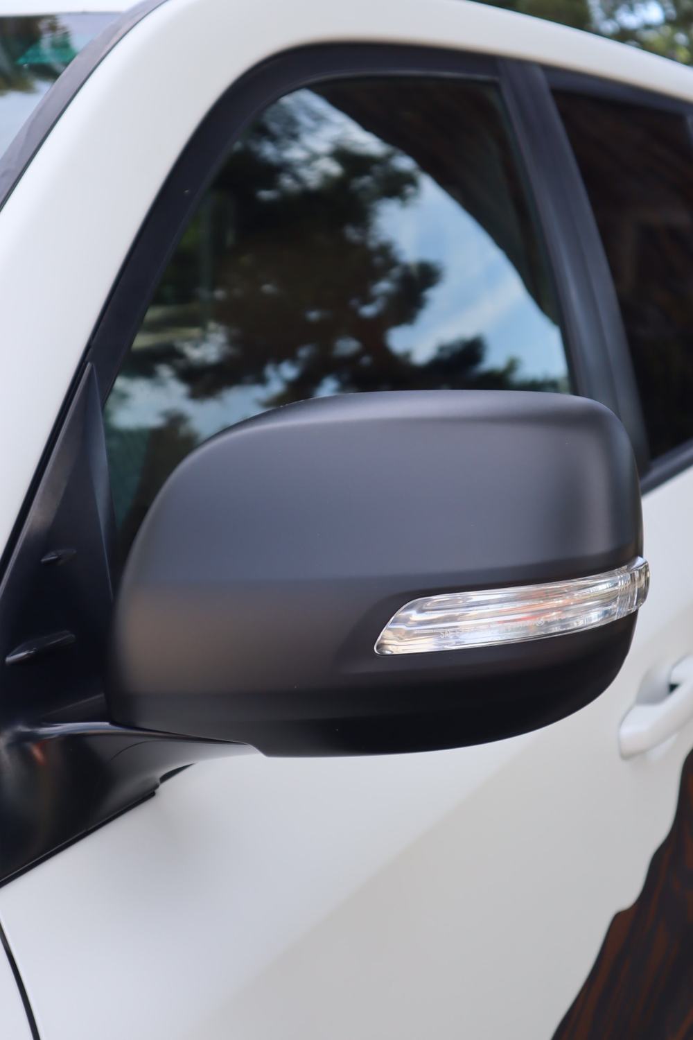 Close-up of the satin finish next to the mirror on a 2016 Toyota Land Cruiser with full-body matte PPF over custom graphics by Drift Wraps in Rancho Cordova