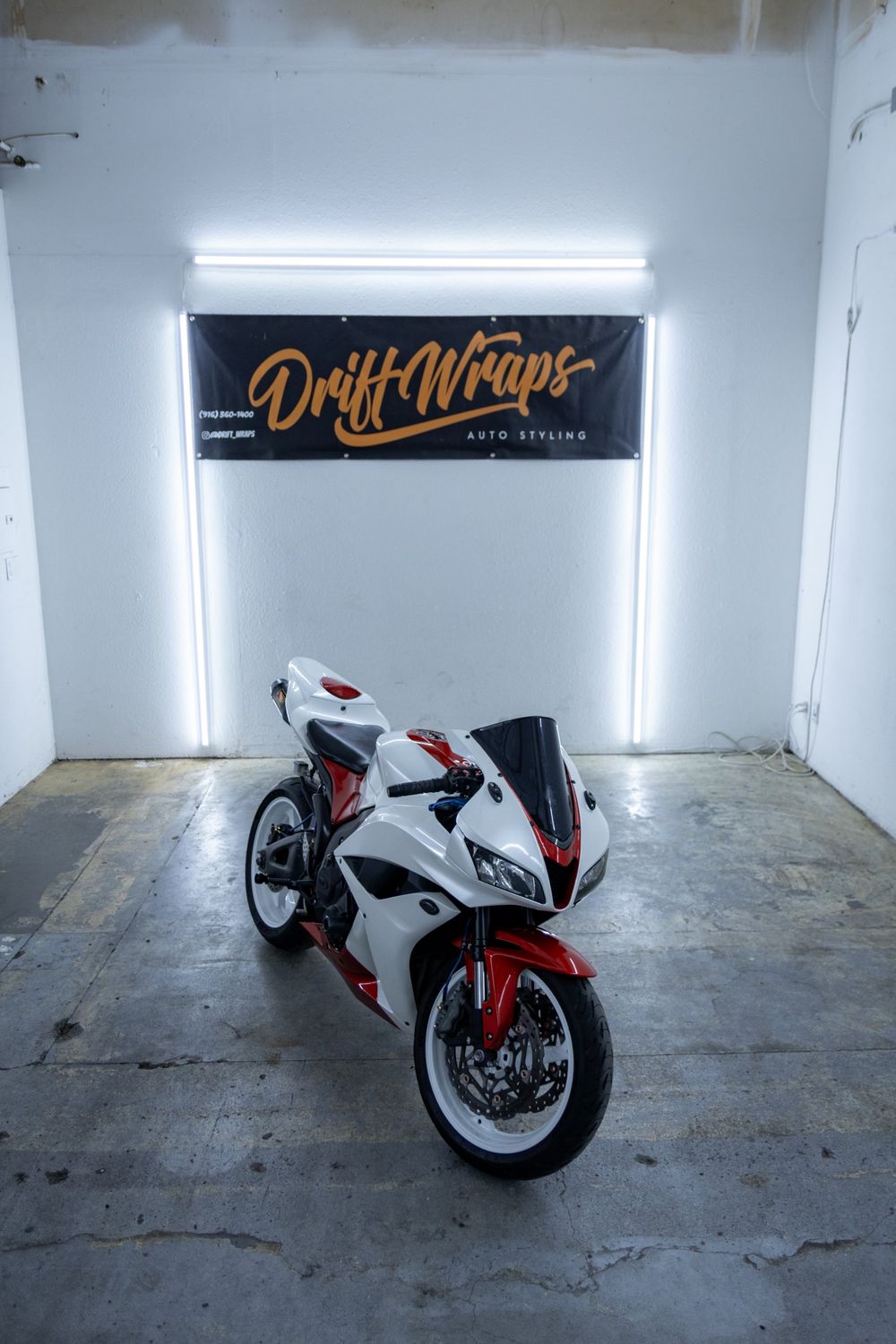 Front of a Honda CBR with a custom white and red wrap in 3M Gloss Dragon Fire Red and Avery Dennison Gloss White Pearl by Drift Wraps