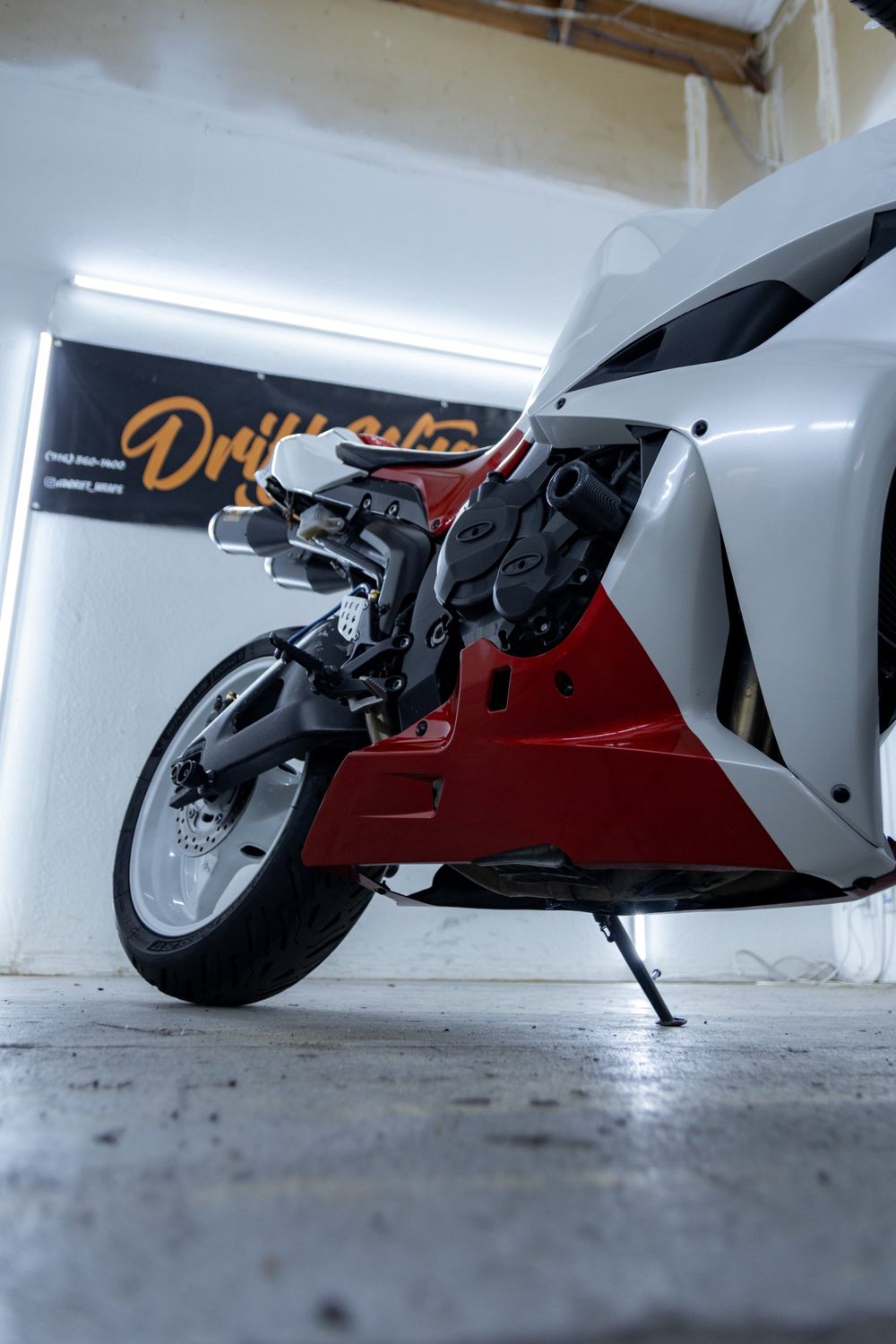 Lower fairing of a Honda CBR with a custom white and red wrap in 3M Gloss Dragon Fire Red and Avery Dennison Gloss White Pearl by Drift Wraps