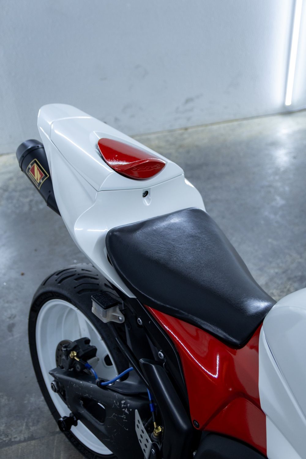 Tail section of a Honda CBR with a custom white and red wrap in 3M Gloss Dragon Fire Red and Avery Dennison Gloss White Pearl by Drift Wraps