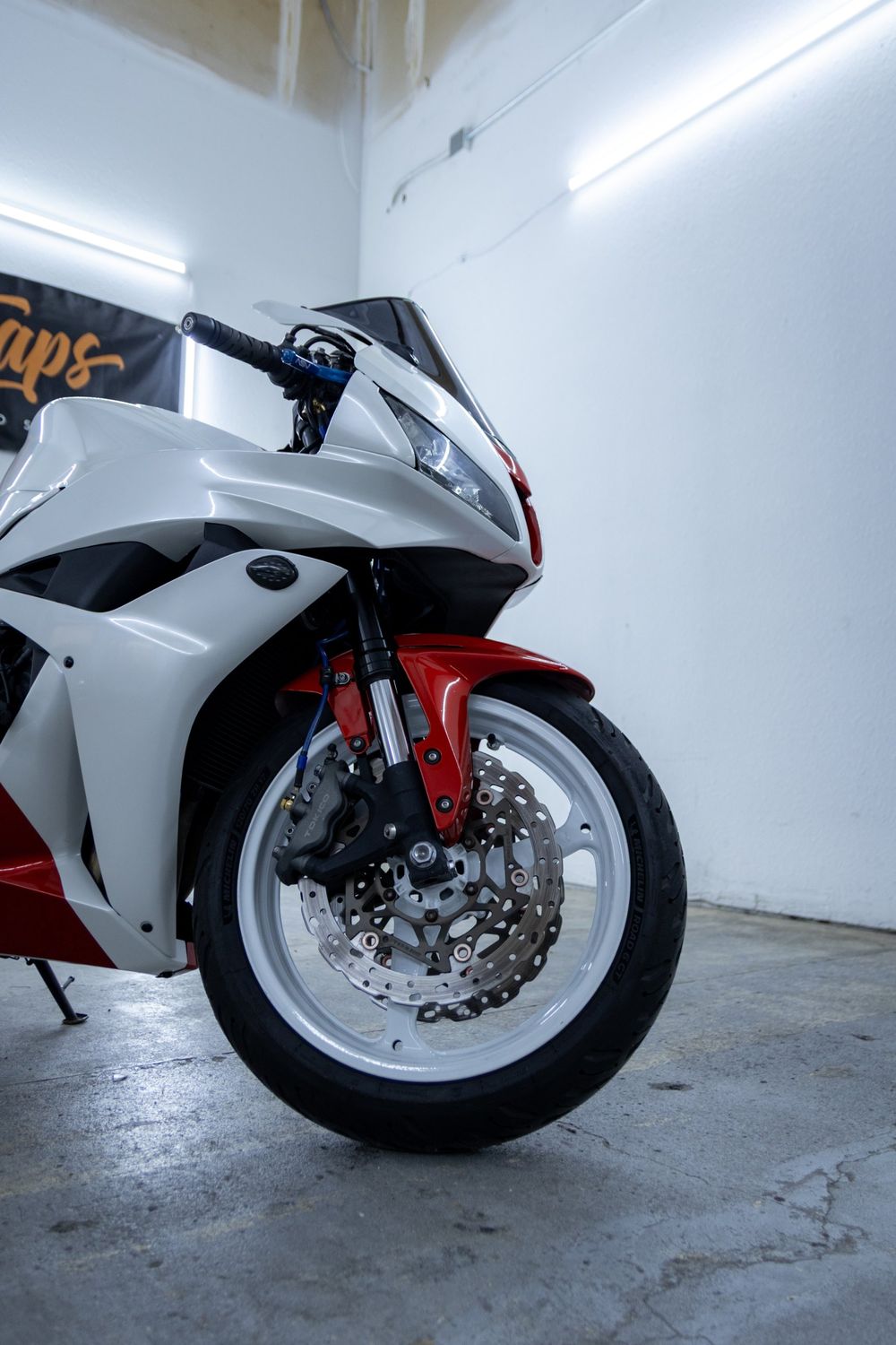 Front fairing and fender of a Honda CBR with a custom white and red wrap in 3M Gloss Dragon Fire Red and Avery Dennison Gloss White Pearl by Drift Wraps