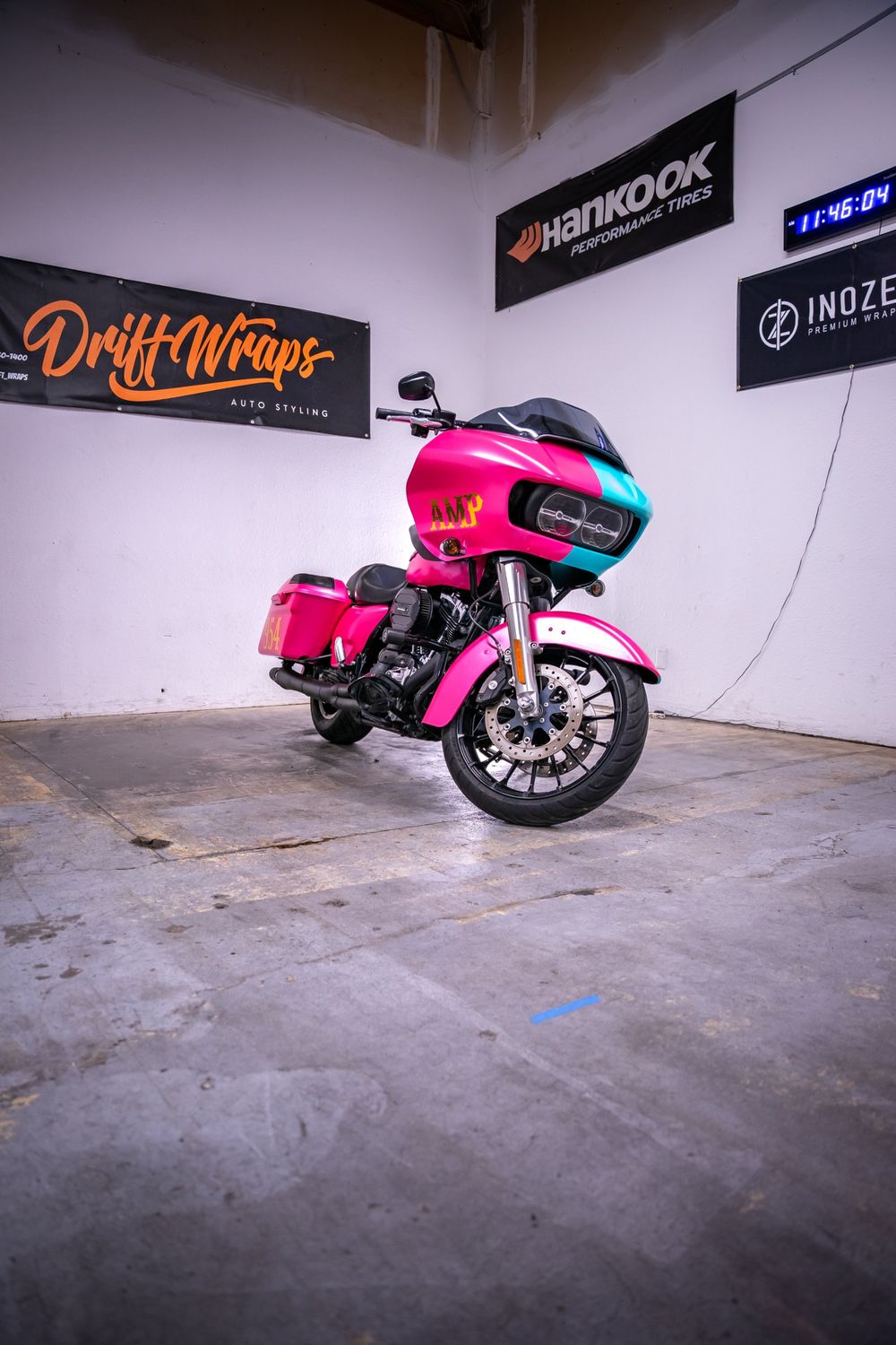 Gold chrome numbers on the saddlebag of a Harley-Davidson Road Glide with a half pink, half teal themed wrap by Drift Wraps