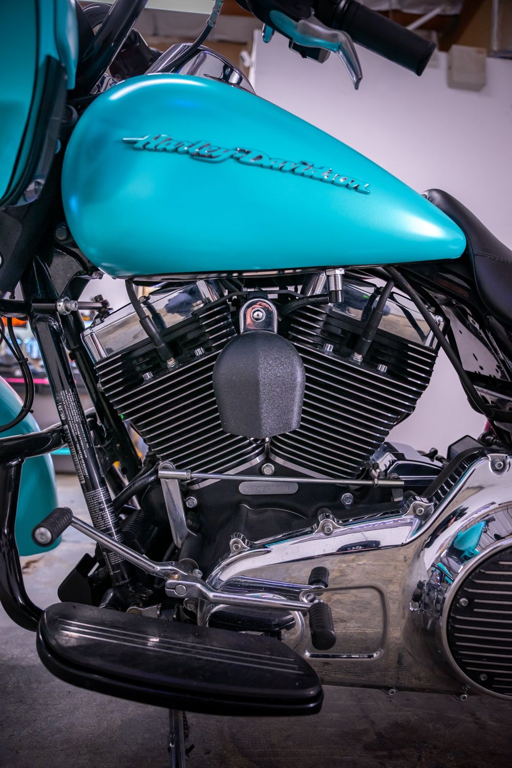 Teal side of the tank on a Harley-Davidson Road Glide with a half pink, half teal themed wrap by Drift Wraps