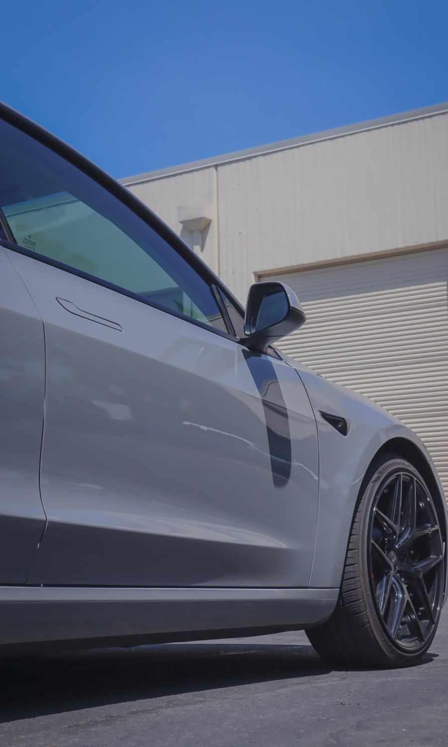 Door and fender of a Tesla Model 3 wrapped in 3M High Gloss Nardo Gray by Drift Wraps