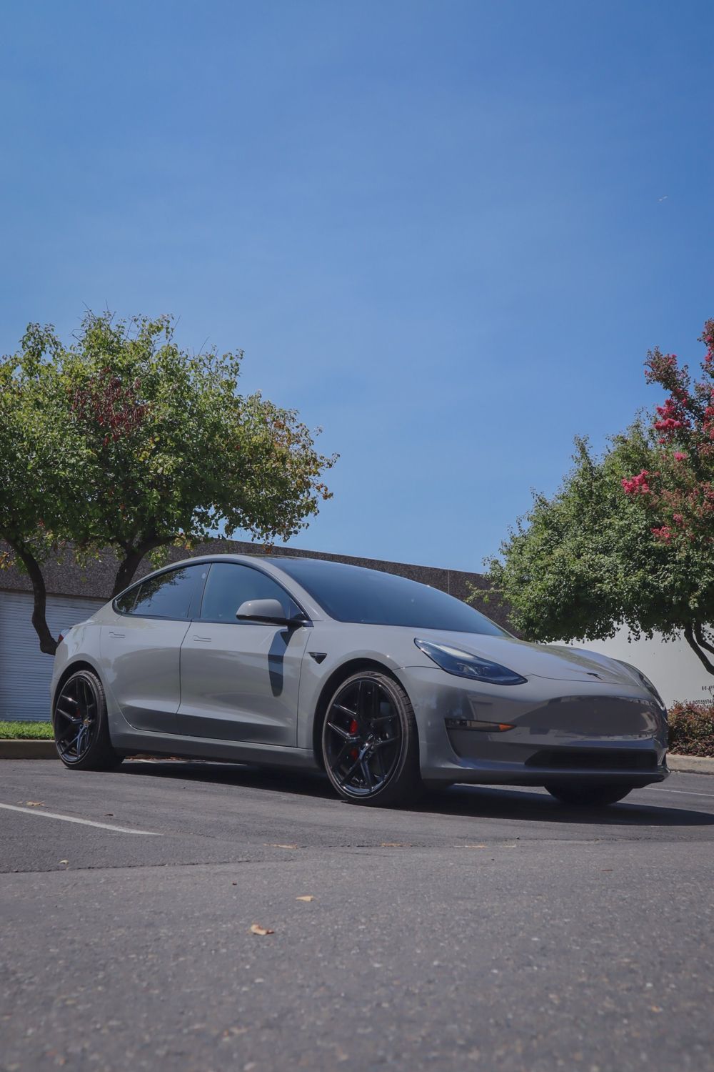 Front three-quarter view of a Tesla Model 3 wrapped in 3M High Gloss Nardo Gray by Drift Wraps