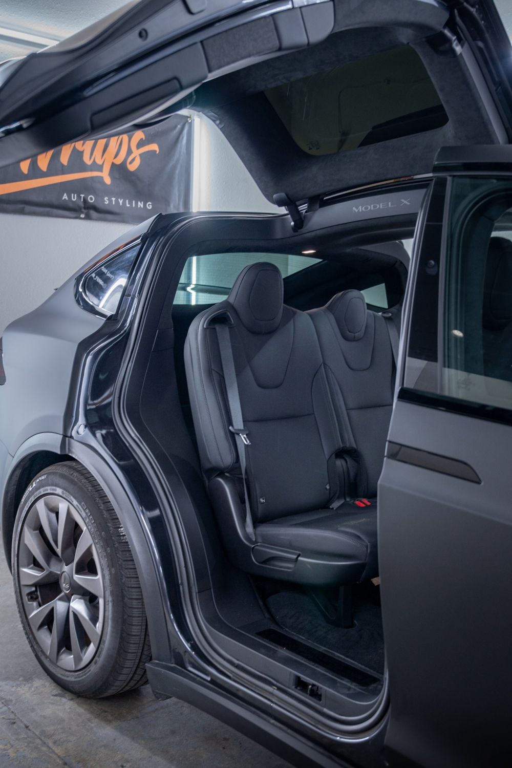 Open rear door on a Tesla Model X wrapped in 3M Dead Matte Black by Drift Wraps