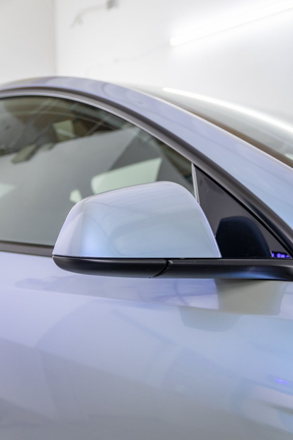 Mirror close-up on a Tesla Model Y wrapped in TeckWrap Gloss Azure Maya Blue by Drift Wraps