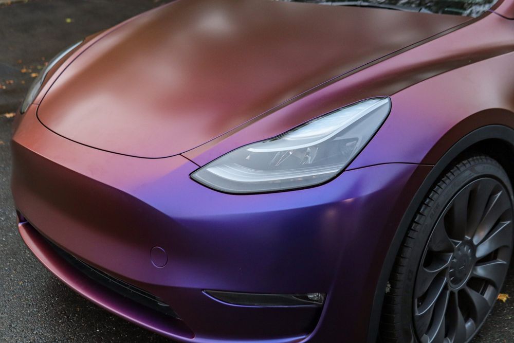 Headlight close-up on a Tesla Model Y wrapped in Avery Dennison Satin Roaring Thunder by Drift Wraps