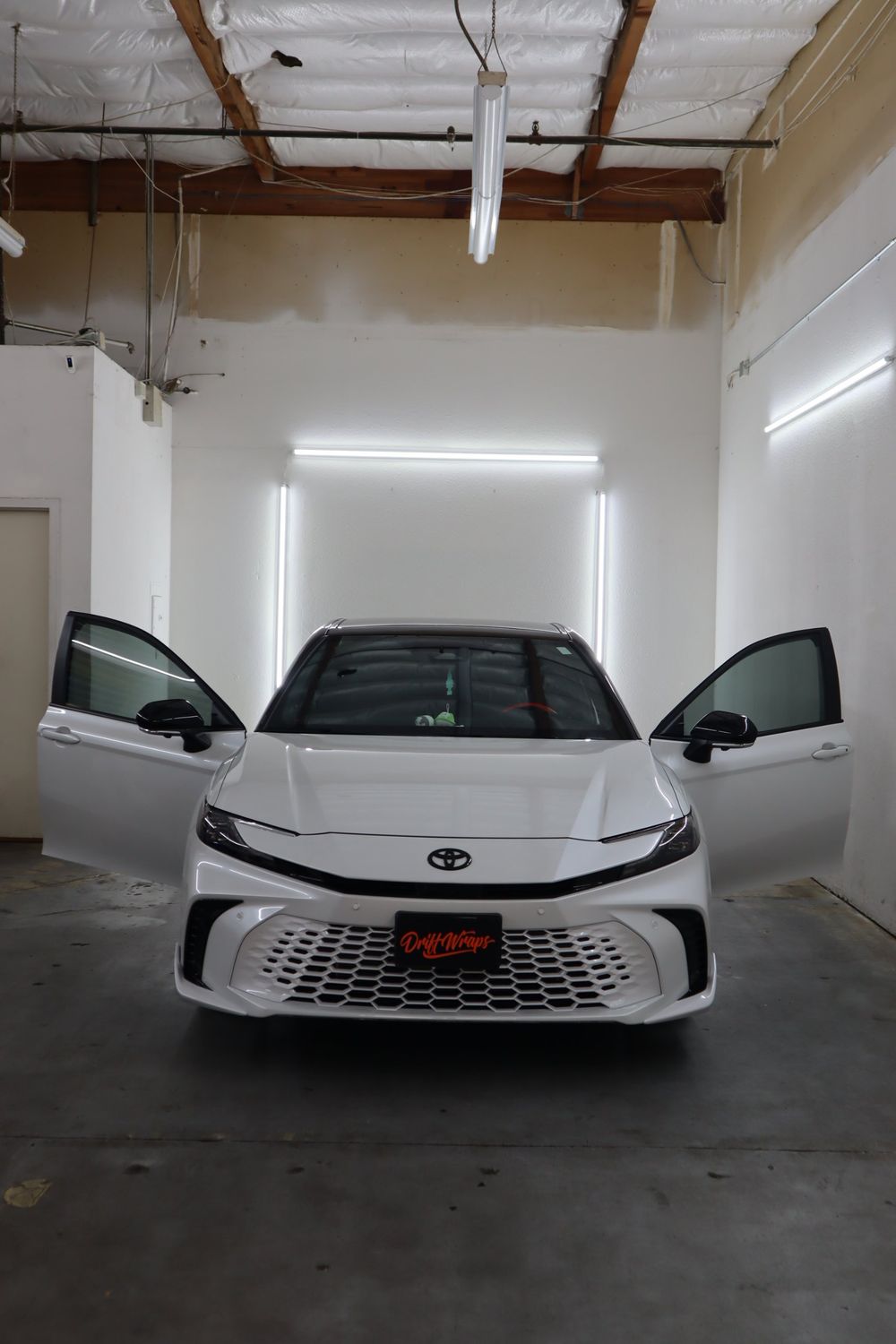 Doors open on a white Toyota Camry with LLumar ceramic window tint by Drift Wraps in Rancho Cordova