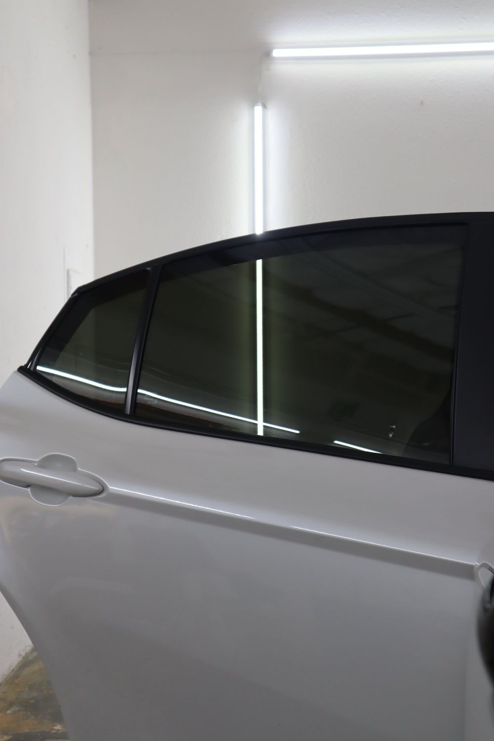 Tinted rear door windows on a white Toyota Camry with LLumar ceramic window tint by Drift Wraps in Rancho Cordova