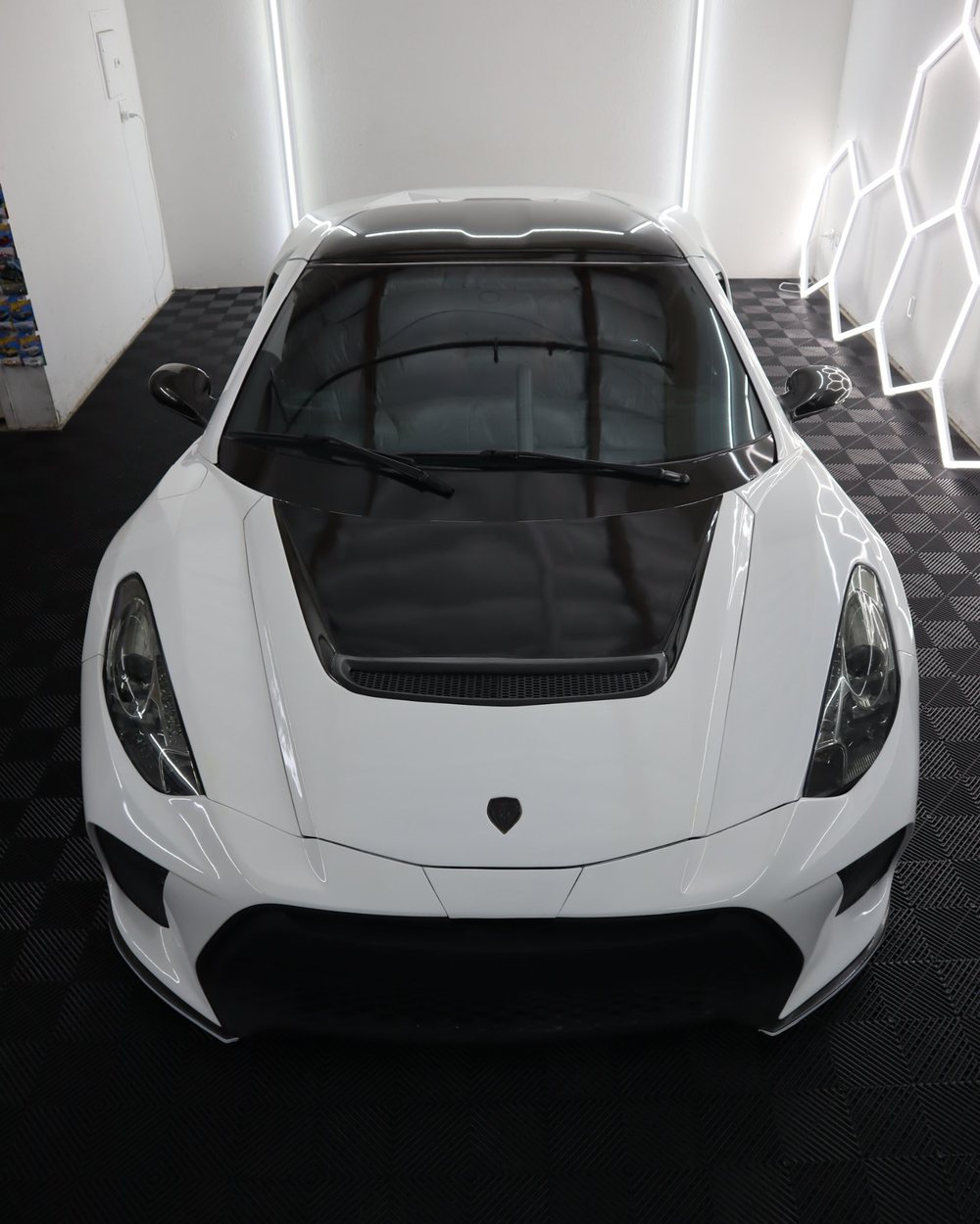 Top-down view of a one-of-ten custom-built white supercar with LLumar ceramic window tint in the Drift Wraps studio in Rancho Cordova