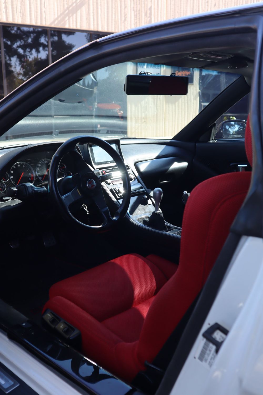 Interior view through tinted glass of a white Acura NSX with LLumar ceramic window tint by Drift Wraps in Rancho Cordova