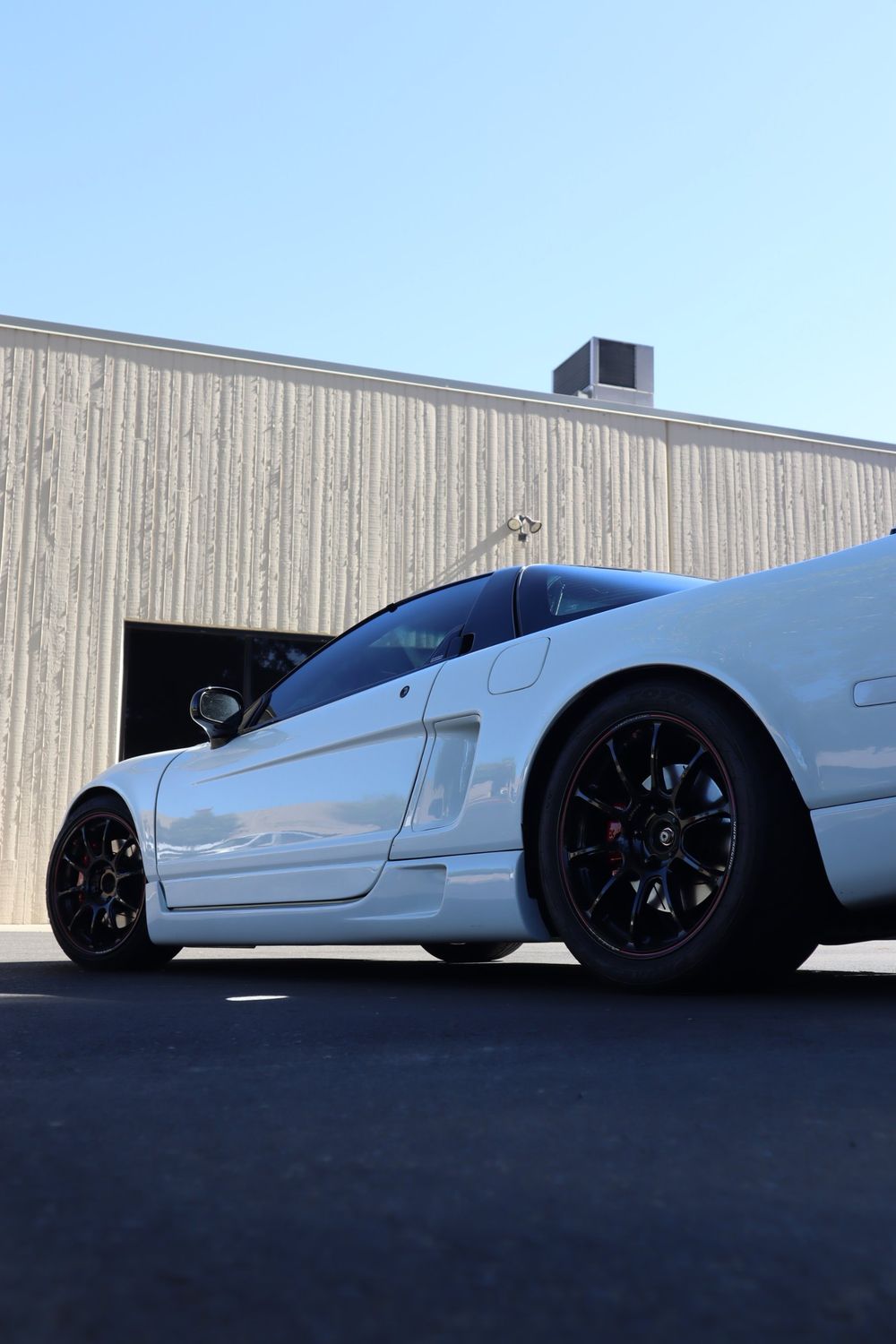 Low rear quarter view of a white Acura NSX with LLumar ceramic window tint by Drift Wraps in Rancho Cordova